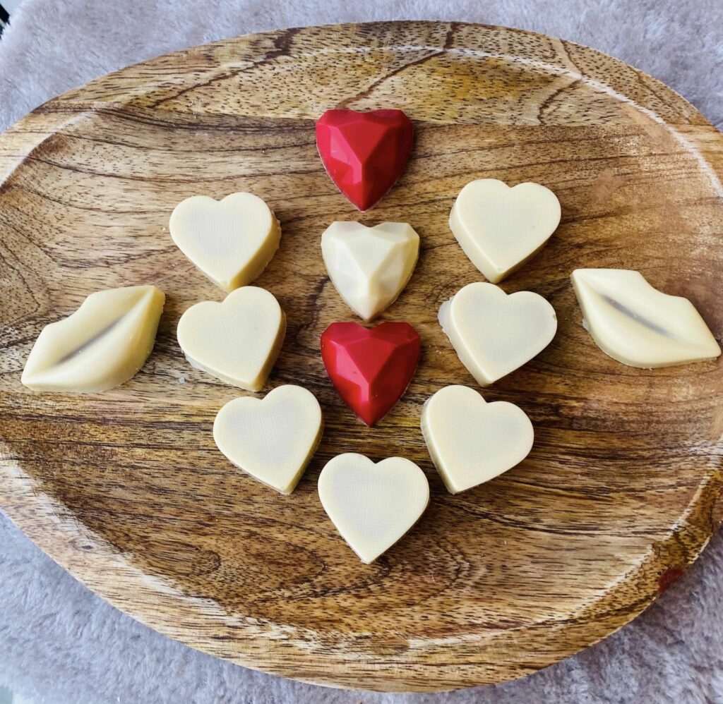 Plateau en bois garni de cœurs en chocolat blanc et rouge